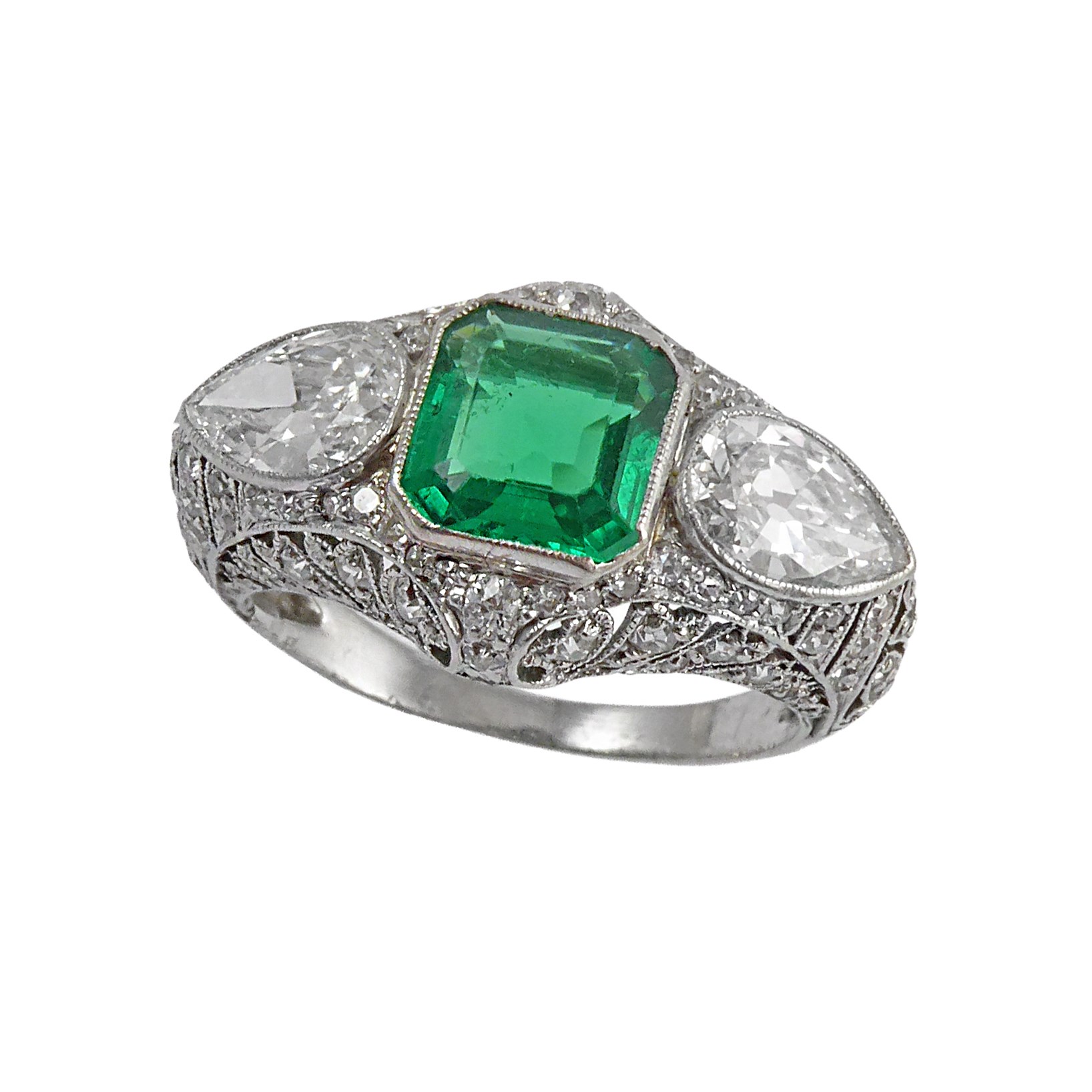 Early 20th century three stone emerald and diamond ring, c.1910, central emerald-cut Colombian emerald of rectangular form, approximately 1.30ct,
